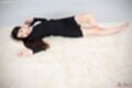 Lying on her back knee drawn up bare feet