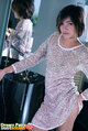Standing beside mirror wearing dress