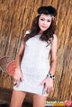 Standing with arms down by her sides wearing silver dress