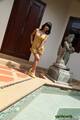 Standing beside swimming pool wearing high heels